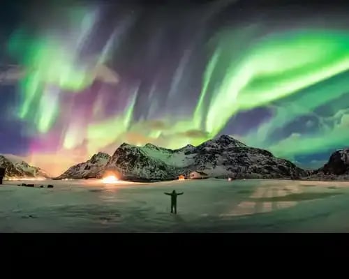 aurora-borealis-(northern-lights)-over-mountain-with-one-person-at