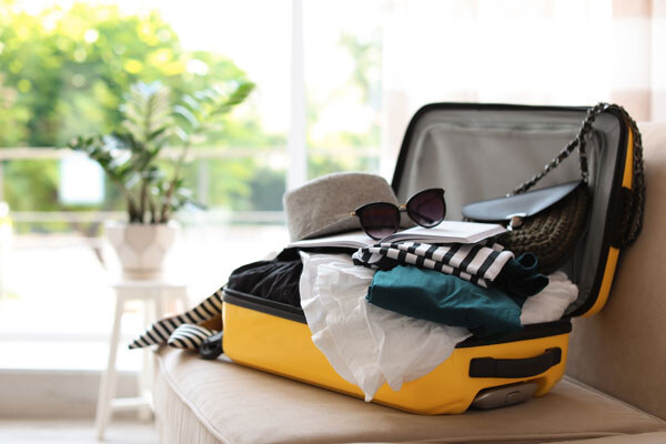open-yellow-suitcase-with-different-clothes-packed-for-journey-at