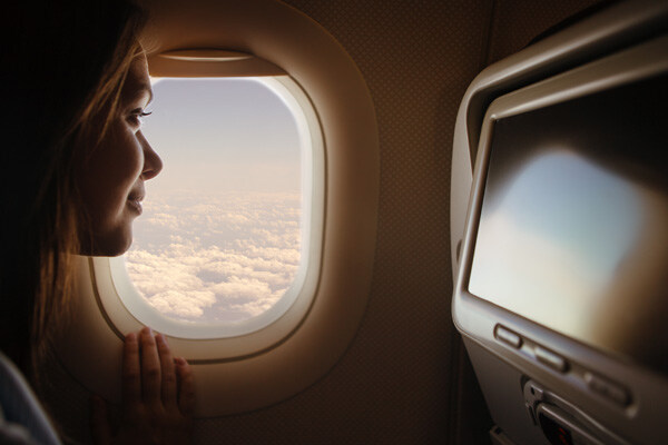 woman-looking-through-window-in-airplane