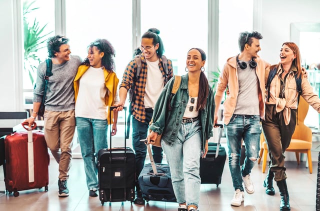 young-group-of-tourists-with-suitcases-arriving-at-youth-hostel-1