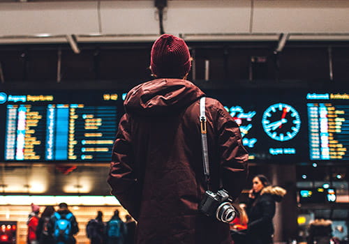 study-abroad-student-in-beanie-looking-at-flight-schedule-in-oslo-norwayjpg