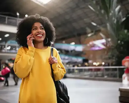 beautiful-afro-woman-using-mobile-in-the-train-station