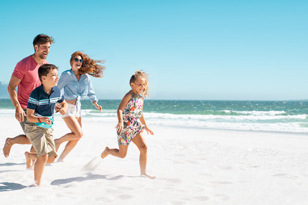 cheerful-young-family-running-on-the-beach-with-copy-space