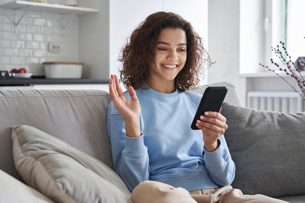 happy-hispanic-teen-girl-waving-hand-using-smartphone-app-enjoying