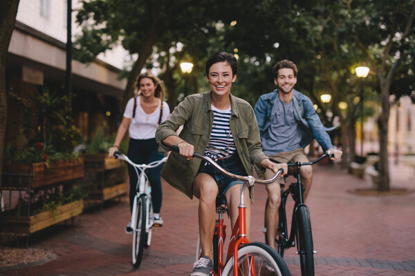 three-young-people-cycling-down-the-street