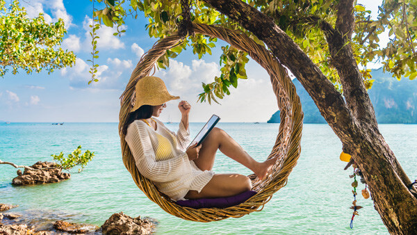 traveler-woman-relaxing-on-straw-nests-using-tablet-at-railay