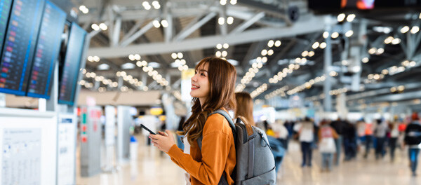 young-asian-woman-in-international-airport--using-mobile-smartphone-and
