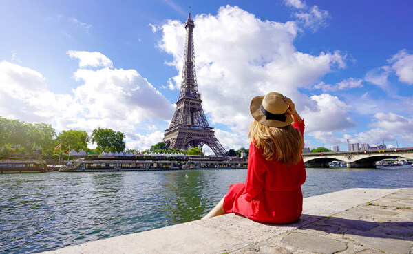 young-traveler-woman-in-red-dress-and-hat-sitting-on