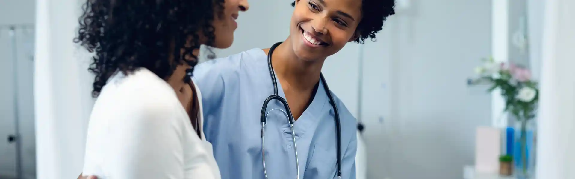 front-view-of-happy-african-american-female-doctor-helping-female