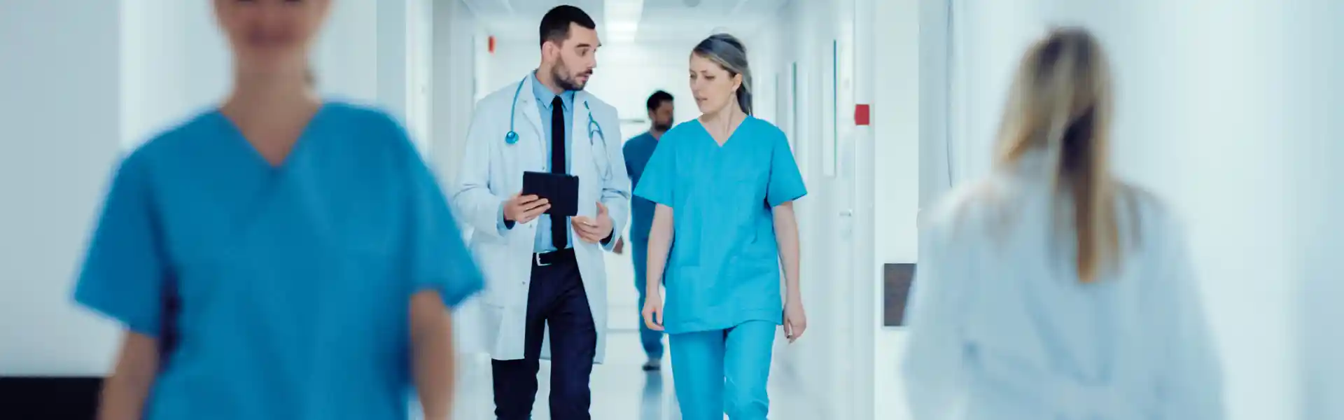 surgeon-and-female-doctor-walk-through-hospital-hallway--they-consult
